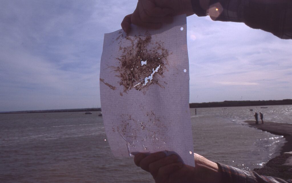 a photo of a pair of hands holding a piece of paper with a hole in it